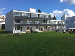 une grande maison blanche avec une pelouse devant elle dans l'établissement Ferienwohnung Marion, à Sankt Englmar