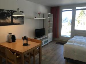 a bedroom with a table and a bed and a table and a dining room at Ferienwohnung Marion in Sankt Englmar