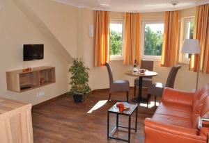 a living room with a couch and a table at Hotel Karl's Burg in Kolpinsee