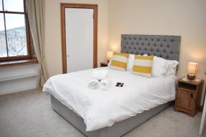 um quarto com uma cama grande com duas alianças de casamento em East Claremont - beautiful 2BR apartment in Central Edinburgh em Edimburgo