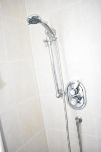 a shower with a shower head in a bathroom at East Claremont - beautiful 2BR apartment in Central Edinburgh in Edinburgh