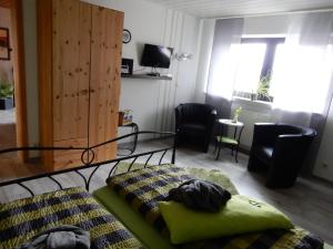 een slaapkamer met een bed en een woonkamer bij Pension-Jakobs in Nachtsheim