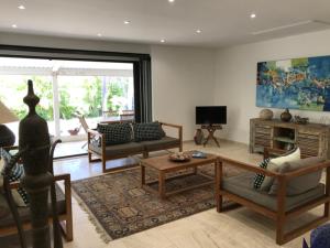 sala de estar con sofás y TV en Villa Jasmin avec piscine chauffée à 50m plage et lagon, en Saint-Gilles-les-Bains