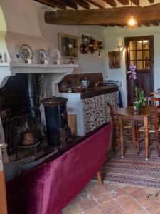 a living room with a fireplace and a table and a kitchen at Le Pontin in Mane