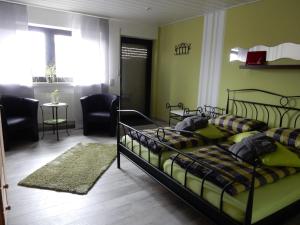 a bedroom with a bed and a living room at Pension-Jakobs in Nachtsheim