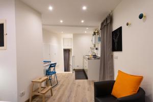 ein Wohnzimmer mit einem Sofa und einer Küche in der Unterkunft Il Palio suite Casato di Sopra in Siena