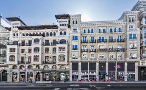 a large white building with blue windows on a street at Catalonia Gran Vía Madrid in Madrid