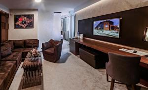 a living room with a couch and a tv at Hotel President Sarajevo in Sarajevo