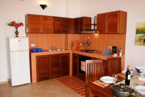 cocina con armarios de madera y nevera blanca en Casa Bahia 11, en Santa Maria