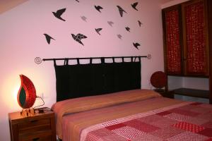 1 dormitorio con 1 cama con murciélagos en la pared en Casa Bahia 11, en Santa Maria