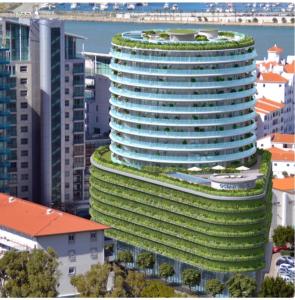 a tall building with a green roof in a city at Luxe Holiday Rentals in Gibraltar