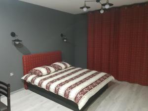 una camera con letto rosso e tenda rossa di Апартаменты Yes Silver a Užhorod