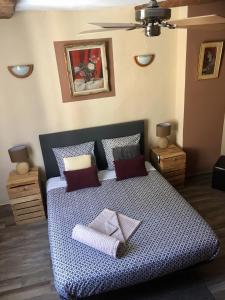 a bedroom with a bed with a blue and white comforter at Lou Mistral in Moustiers-Sainte-Marie