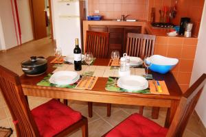 una mesa de comedor con platos y una botella de vino en Casa Bahia 11, en Santa Maria