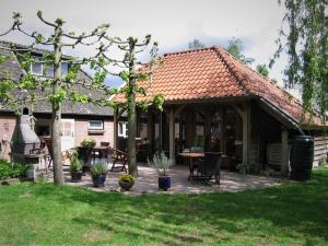 a pavilion with a table and chairs in a yard at Bed&Breakfast 't Eikeltje in Hollandscheveld