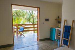 a room with a door open to a balcony with a table and chairs at BEACHES Bonaire in Kralendijk