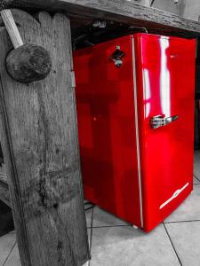 een rode koelkast naast een houten deur bij La casa degli zii in Ferrara