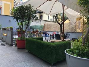 un patio al aire libre con mesa, sillas y sombrilla en Ostello Old Milano, en Milán