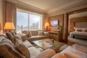 a living room with a couch and a bed at Gulf Hotel Bahrain in Manama