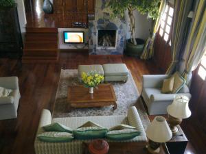 a living room with two couches and a fireplace at Bed & Breakfast Chiang Rai in Ban Du