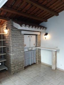 an outdoor kitchen with a brick wall and a stove at Apartments Kule in Brela