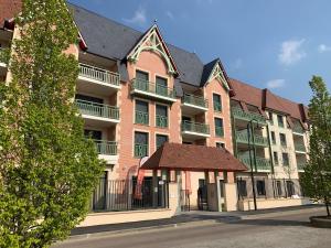 um edifício de apartamentos com um gazebo em frente em Résidence Services Seniors Domitys - Les Safrans em Dives-sur-Mer