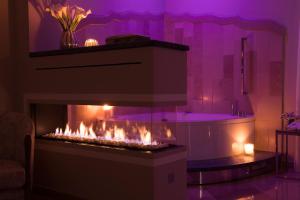 a fireplace in a living room with purple lighting at Hotel Don Ferrante in Monopoli