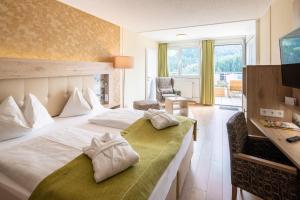 Una habitación de hotel con una cama con toallas. en Panorama Hotel Turracher Höhe, en Turracher Höhe