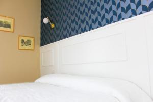 1 dormitorio con cama blanca y papel pintado azul en Don Raffaele Resort en Nápoles