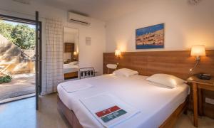 a bedroom with a large white bed and a window at Mellieha Holiday Centre in Mellieħa