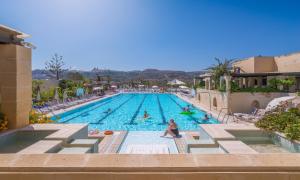 a large swimming pool with people sitting in it at Mellieha Holiday Centre in Mellieħa