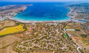 an aerial view of a city and the ocean at Mellieha Holiday Centre in Mellieħa