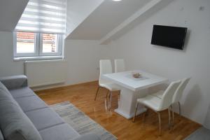 a living room with a couch and a table with chairs at Apartment Harmony in Višegrad