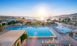 an overhead view of a large swimming pool with chairs at Mellieha Holiday Centre in Mellieħa