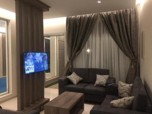  شاليهات هان ريڤر الفندقية  في الطائف: غرفة معيشة مع أريكة وتلفزيون بشاشة مسطحة