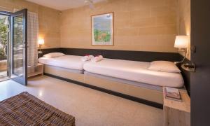 two beds sitting in a room with a window at Mellieha Holiday Centre in Mellieħa