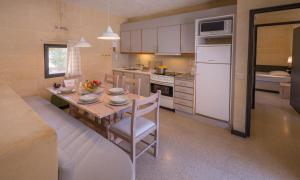 a kitchen with a table and a white refrigerator at Mellieha Holiday Centre in Mellieħa