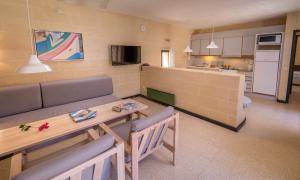 a living room with a table and chairs and a kitchen at Mellieha Holiday Centre in Mellieħa