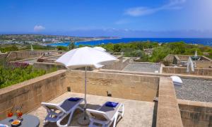 a patio with two chairs and an umbrella at Mellieha Holiday Centre in Mellieħa