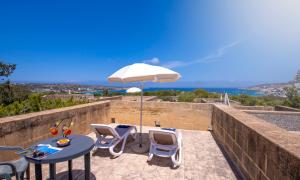 a patio with a table and chairs and an umbrella at Mellieha Holiday Centre in Mellieħa