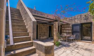 a stone house with a patio with a table at Mellieha Holiday Centre in Mellieħa