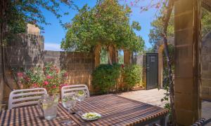 a table and chairs on a patio with a fence at Mellieha Holiday Centre in Mellieħa
