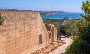a brick wall with a view of the ocean at Mellieha Holiday Centre in Mellieħa