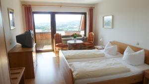ein Hotelzimmer mit einem Bett und einem Balkon in der Unterkunft Gasthof Adler Güttingen in Güttingen