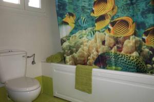 ein Bad mit einem WC und einer Wand mit Fischmotiven in der Unterkunft chrisa's apartment in Volos