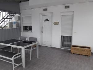 Zimmer mit einem Tisch, Stühlen und einer Tür in der Unterkunft chrisa's apartment in Volos