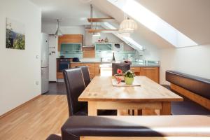 a kitchen and dining room with a wooden table and chairs at Weingut Jakob`s Ruhezeit in Mautern