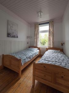 2 bedden in een slaapkamer met een raam bij Terrassenwohnung-Loenneberger-im-Ferienhof-Nielson in Bisdorf