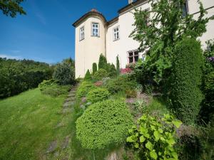 una casa antigua con un jardín delante de ella en EA Hotel Hrubá Skála, en Hrubá Skála