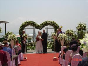 Una novia y un novio parados frente a un arco cardíaco en Alishan B&B YunMinGi en Fenchihu